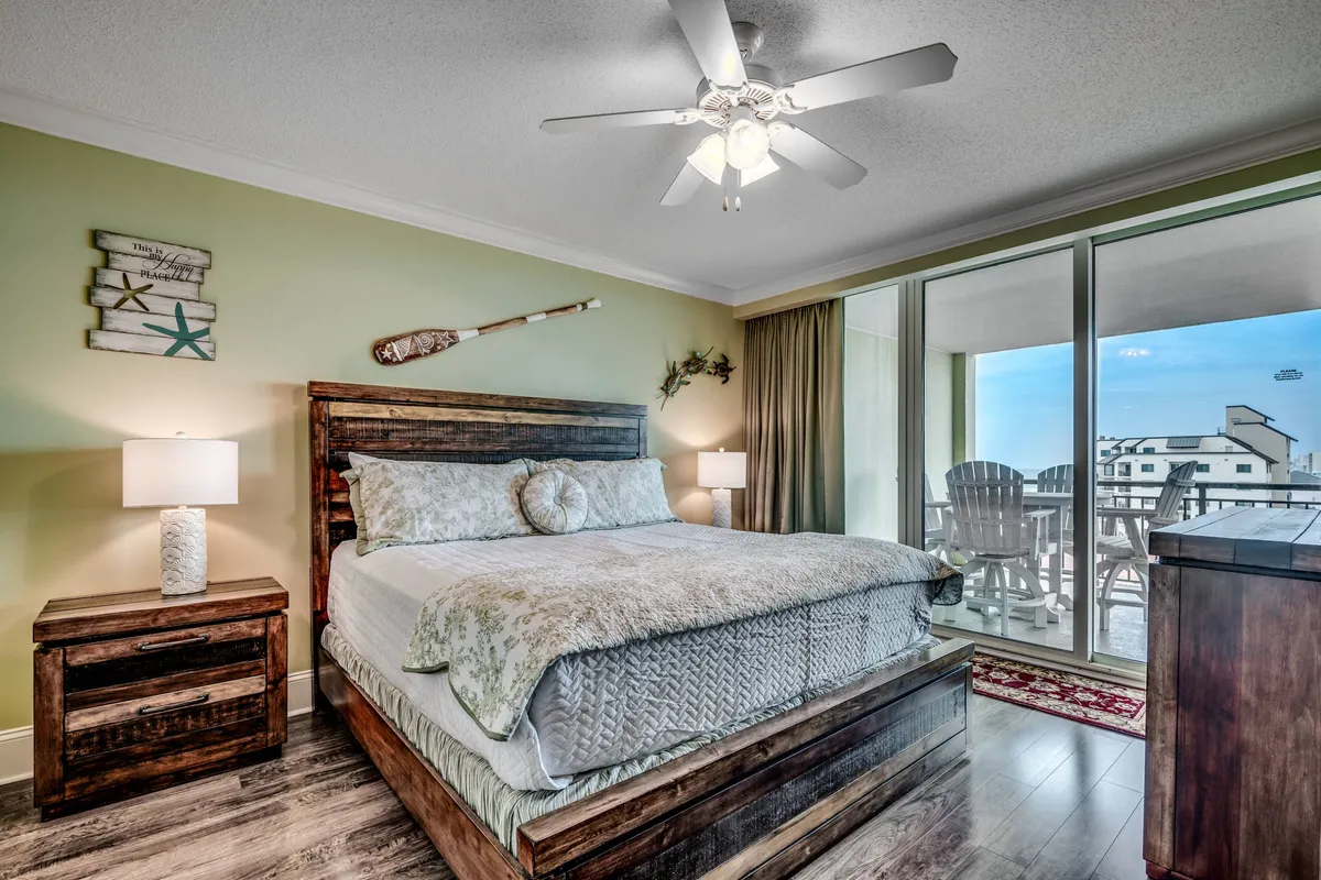 This image features a tranquil bedroom retreat with a plush bed adorned with decorative pillows, wooden furniture, and expansive windows offering a scenic view. The tones are peaceful, and the space exudes a sense of relaxation, perfect for unwinding after a busy day.