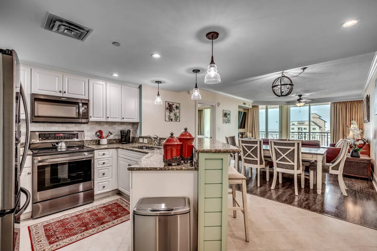 A modern kitchen and dining area with a central island, ample counter space, and stylish red accents. The space is designed for preparing meals, casual conversations, and entertaining guests, providing a seamless connection between cooking and socializing.