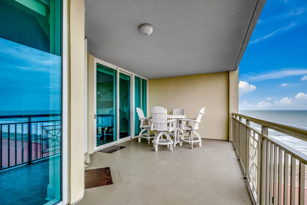 A serene private balcony with an outdoor dining table, ocean view, and balcony railing. The setting is ideal for enjoying coffee at sunrise, al fresco meals, or evening cocktails while immersed in the soothing sounds of the waves.